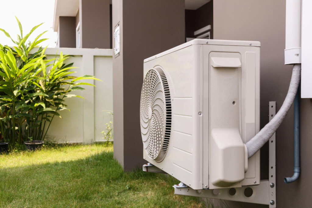 Side view of a house featuring a white air conditioner unit.